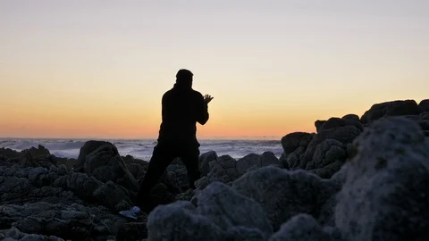 Men warrior monk practicing silhouette tai chi karate kung Fu on the rocky Stock Footage 124296739