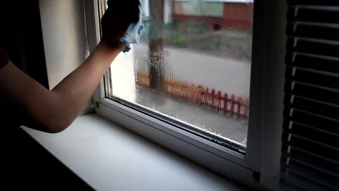Men washes windows in home. Cleaning window with a wash spray and a duster. Stock Footage 127281784