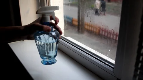 Men washes windows in home. Cleaning window with a wash spray and a duster. Stock Footage 127281870