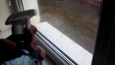 Men washes windows in home. Cleaning window with a wash spray and a duster. Stock Footage 127282064