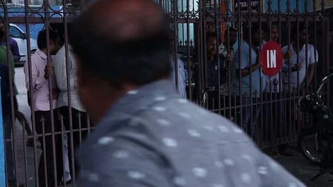 Men-watch-a-public-protest-behind-a-gate Stock Footage 119487590