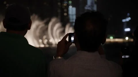 To men watching the Dubai light and water fountain show at the downtown, Stock Footage 246563242