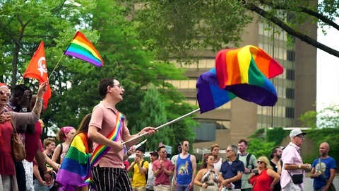 Men waving a pride flag during Montreal Gay Pride LGBTQ+ in Canada Stock Footage 114346685