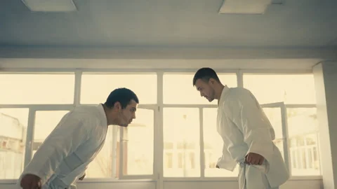 Men in white kimonos bowing to each other before taekwondo sparring, martial art Stock Footage 240209470