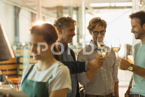 Men wine tasting white wine in winery tasting room Stock Photos