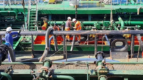 Men work with black hosepipe connecting oil tankers Stock Footage 113194422