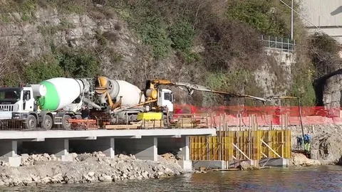 Men at work at a construction site on the lakeshore Stock Footage 73447738
