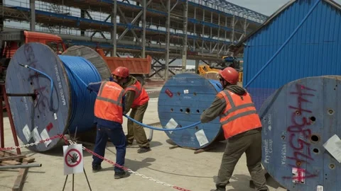 Men work with electric cable in front of the building Video stock 138218096