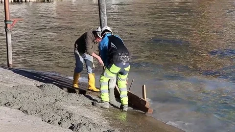 Men at work on lake river with cement and persons Stock Footage 73447771