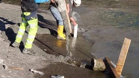 Men at work on lake river with cement fill Stock Footage 73447811