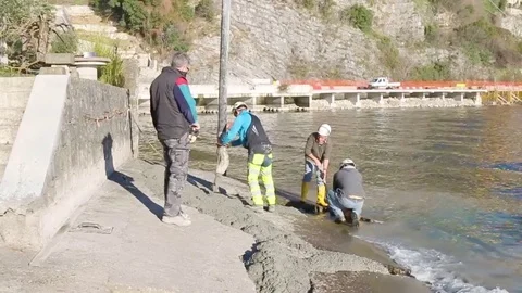 Men at work on lake river with cement Stock Footage 73450474