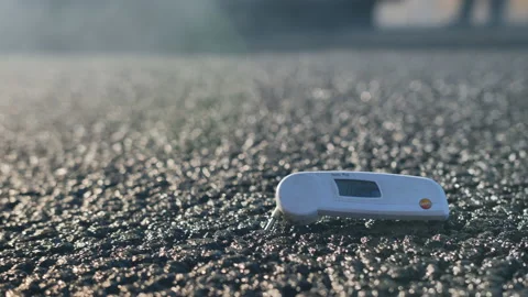 Men at work. Measuring the temperature of freshly laid asphalt. Close-up of out Stock Footage 138157994