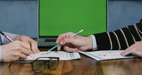 Men work with numbers on paper, against the background of an open laptop Stock Footage 241827893