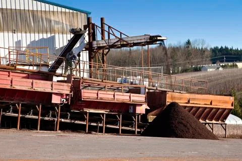 Men at work processing compost for agriculture. Stock Photos
