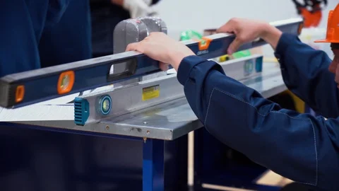 Men workers work in workplace on workbench. Guy holds level, applies it on top Stock Footage 126355712
