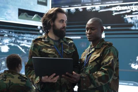 Men working as army officers using laptop in command center Stock Photos