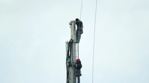 Men working on celular tower top Stock Footage 11618542