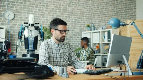 Men working in office using computers and manufacturing 3d printer robot details Stock Footage 119566971