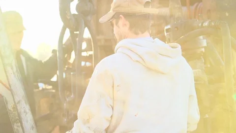 Men working in the oil fields at dusk in Texas Stock Footage 128649336