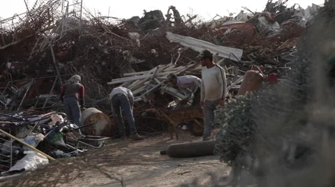 Men Working on a Scrap Yard. Wiring in the foreground. Stock Footage 58625919