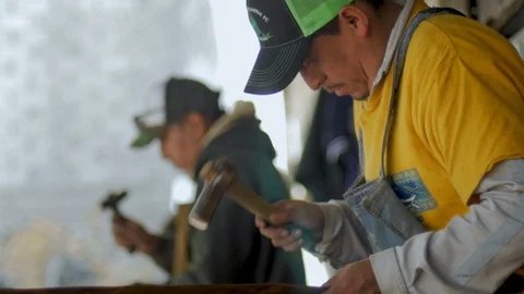 Men working in their workshop hitting copper with hammers in slow motion Stock Footage 98843863