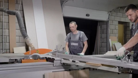 Men working on wood cutting machine standing in uniform in factory Video stock 92127803