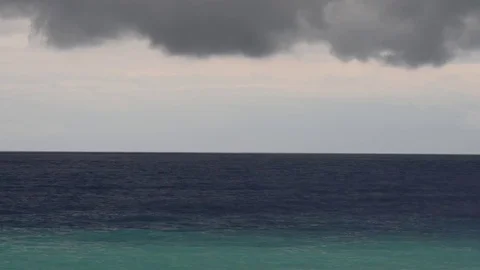 Menacing black clouds leave the clear sky on the dark sea Stock Footage 83389426