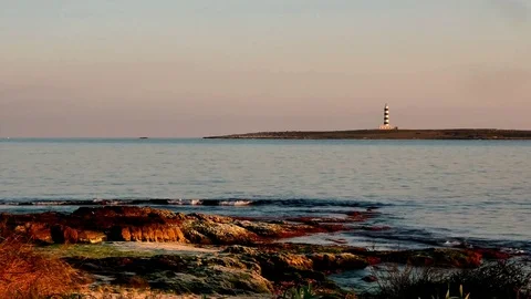 Menorca, Punta Prima with lighthouse in warm evening light Stock Footage 73239188