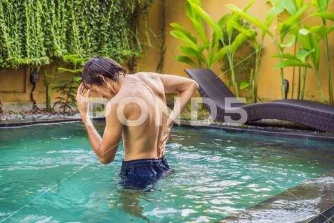 Men's back hurts against the backdrop of the pool. Pool helps with back pain Stock Photos