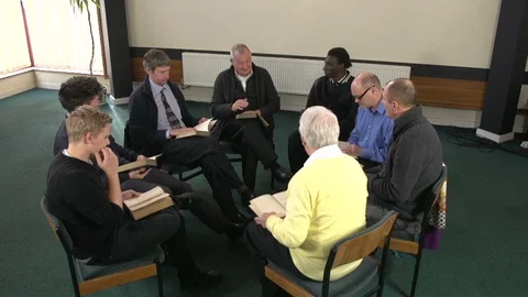 Men's Bible Study Group / Book club -  in a church setting. One man leads Vídeos de archivo 128513835