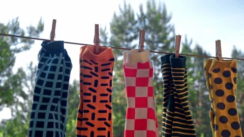 Men's colored socks with different patterns are dried on rope with clothespins. Stock Footage 196980302