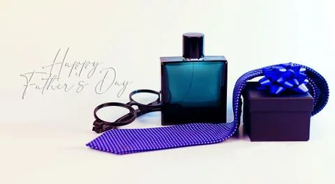 Mens gift concept featuring cologne, eyeglasses, necktie and gift box Stock Photos