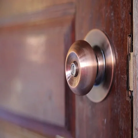 Men's hand opens and closes the brass door knobs Stock Footage 69590189