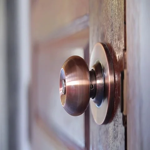 Men's hand opens and closes the brass door knobs Stock Footage 69613229