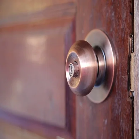 Men's hand opens and closes the brass door knobs Stock Footage 69614346