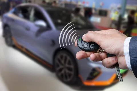 Men's hand presses on the remote control car alarm systems. Stock Photos