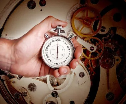 Men's hand with timer on the background of watch mechanism Stock Photos
