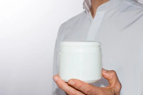 Men's hand with a white plastic container Stock Photos