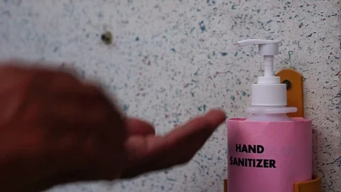 Men's hands are using hand sanitizer mounted on the wall to prevent germs Stock Footage 126023063
