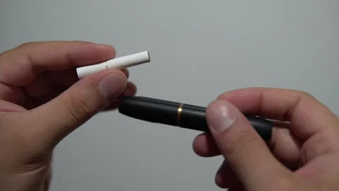 Men's hands cannot insert a cigarette cartridge into the holder Stock Footage 141145205