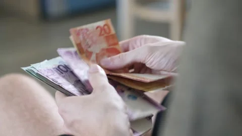 Men's hands count cash Philippine pesos and other currencies at home in a bright Stock Footage 166344440