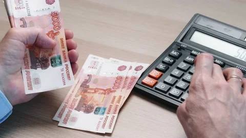 Men's hands count out five thousand Russian rubles and count on a calculator. Stock Footage 172502668