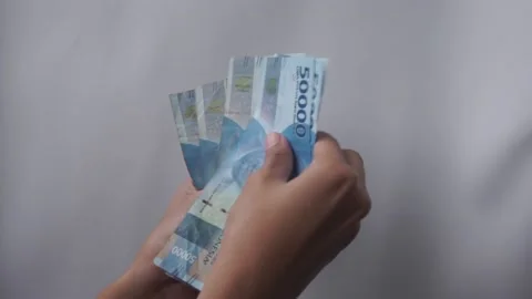 Men's hands counting rupiah banknotes Stock Footage 231589108
