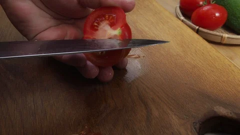 Men's hands cut out the core of a tomato Stock Footage 129807082