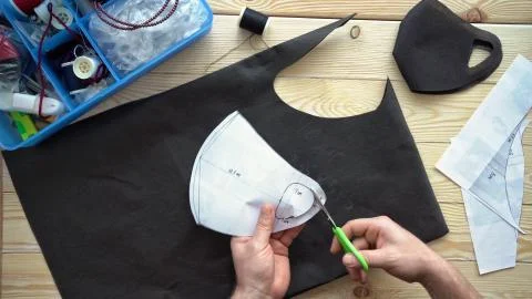 Mens hands cut out pattern mask with scissors. 스톡 사진