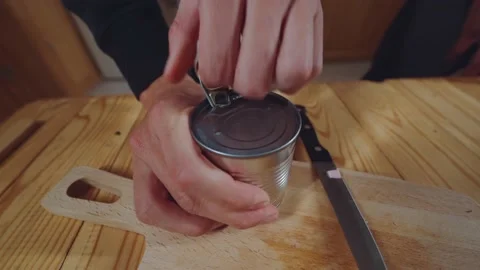 Men's hands do open a can of canned peas Stock Footage 223704151