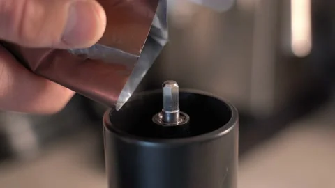 Men's hands fall asleep roasted coffee beans from the packaging in a manual Stock-Footage 230850228