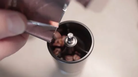 Men's hands fall asleep roasted coffee beans from the packaging in a manual Video stock 230851656