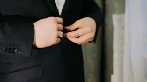 Men's hands fasten a button on a jacket Stock Footage 130764220