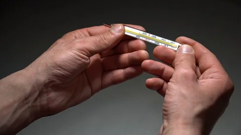 Men's hands hold a thermometer to measure body temperature Stock Footage